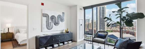 A modern bedroom with a large bed and a view of the city.