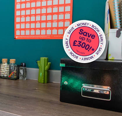 A desk with a green wall and a red poster behind it.