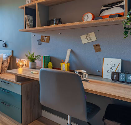 a bedroom with a bed and a desk in a room
