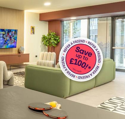 A living room with a sofa, a chair, a table, a bookshelf, and a sign offering a discount.