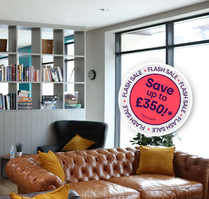 A living room with a brown leather couch and a bookshelf filled with books.