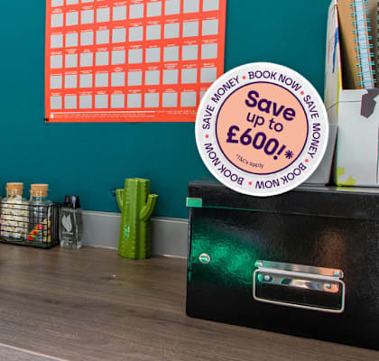 A desk with a black binder and a blue notebook on it.
