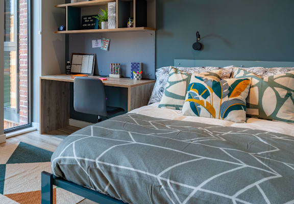 a bedroom with a bed and desk in a 555 waverly unit
