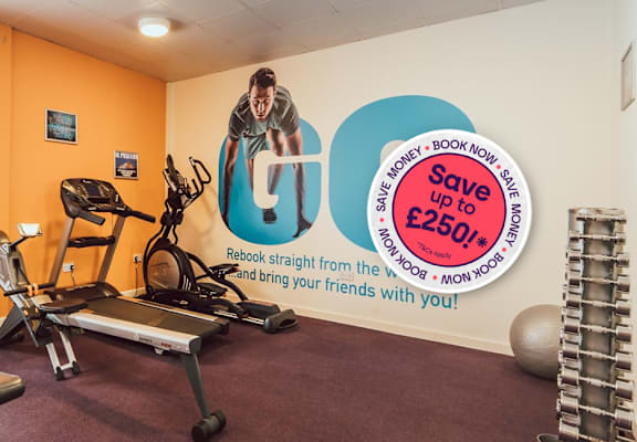 A gym with orange walls has a sign offering a £250 discount.