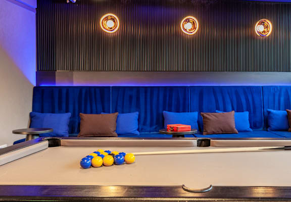 a billiards table in a blue room with balls on it