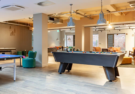 a games room with two ping pong tables and a foosball table