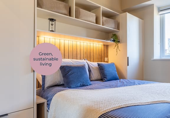 A bedroom with a bed, a lamp, and a sign that says "Green, sustainable living".