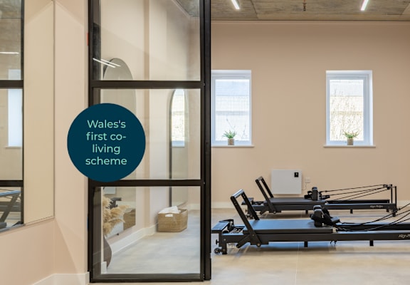 A gym with a sign that says Wales' first co-living scheme.