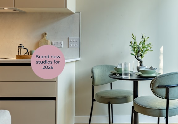 A modern kitchen with a dining table set for two.