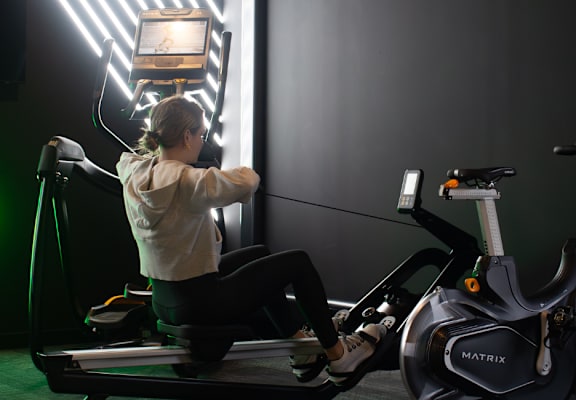 a woman working out on an exercise bike in a gym