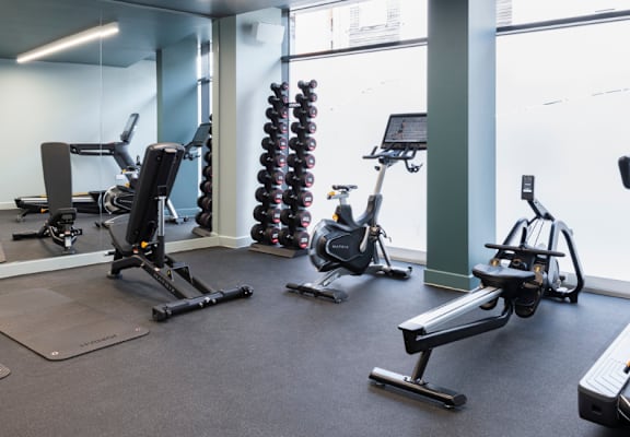 a gym with various exercise equipment and a window