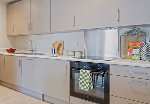 A kitchen with a black oven and white cabinets.