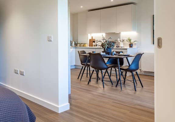 a bedroom with a bed and a dining room with a kitchen