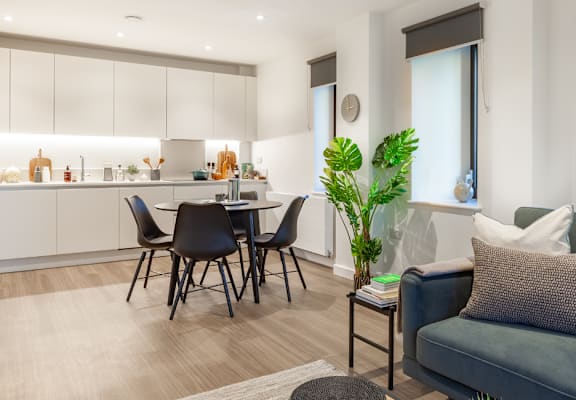 a living area with a couch and a table with chairs