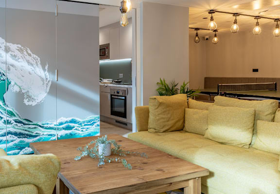 a living room with a large painting of a wave on the wall