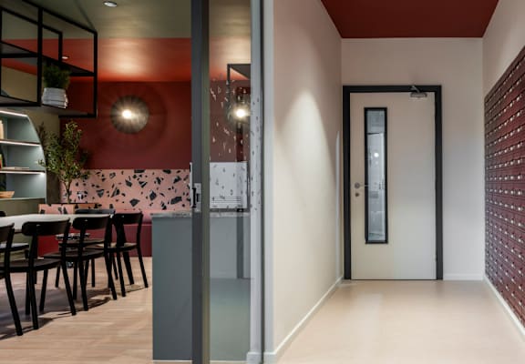 a corridor with a door to a restaurant and a table with chairs