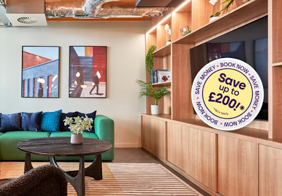 A living room with a sofa, chairs and a television.