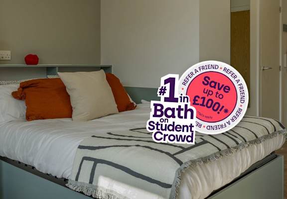 A bedroom with a bed, nightstand, and a sign that says "1# in Bath student Crowd".
