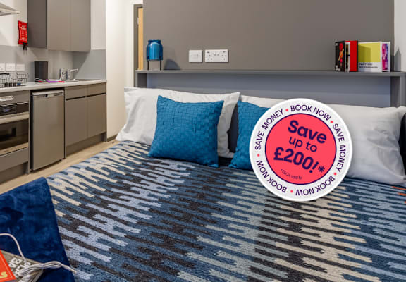 A bedroom with a bed, pillows, and a sign offering a discount.