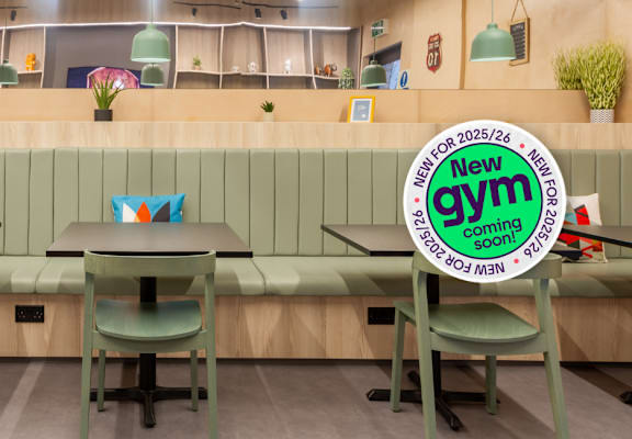 A sign in the foreground announces a new gym opening soon.