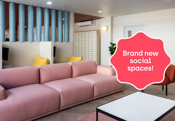a living room with a pink couch and a white table