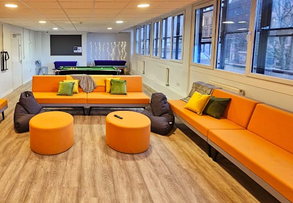 Social space, orange sofas, tv and a pool table