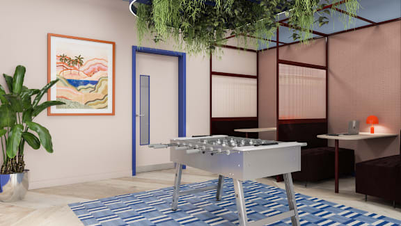 A room with a pool table and a plant.