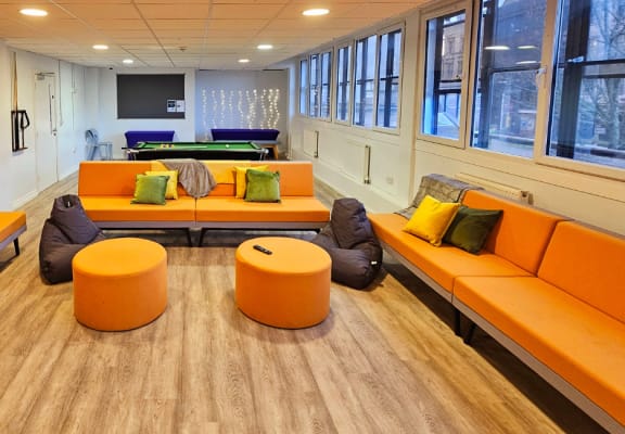 Social space, orange sofas, tv and a pool table