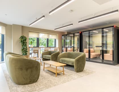 A modern living room with a green sofa and a wooden table.