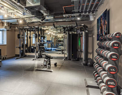 A gym with a variety of equipment including weights and cardio machines.