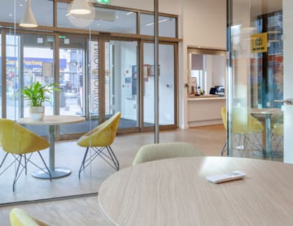 A conference room with a table, chairs and a glass wall.