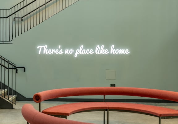 A staircase with a metal railing and a wall with a quote on it.