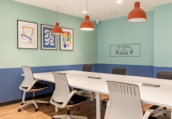 A conference room with a white table and chairs.