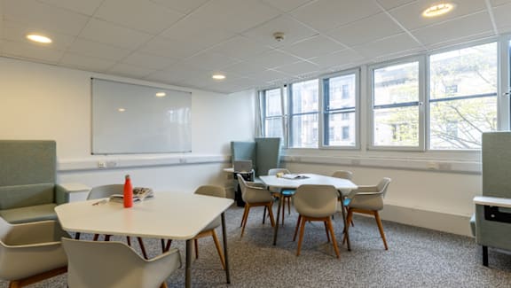 A conference room with a white table and chairs.