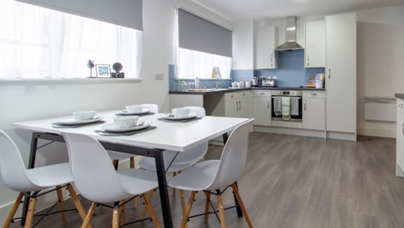 A modern kitchen with a dining table and chairs.
