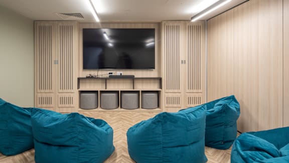 A room with a television and bean bag chairs.