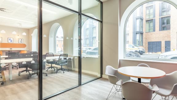 A conference room with a table and chairs and a view of the street outside.