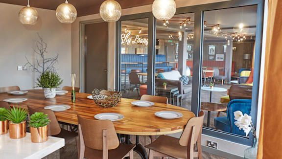 A dining room with a wooden table and chairs.