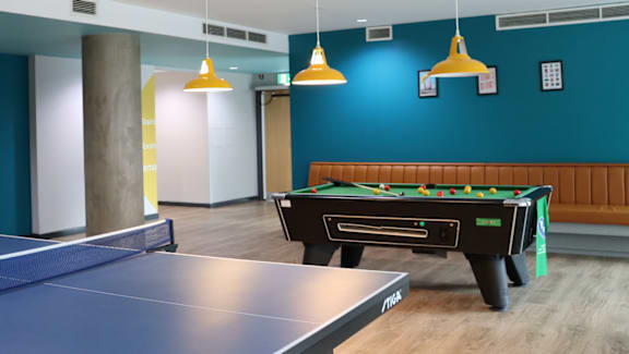 A room with a pool table and ping pong table.