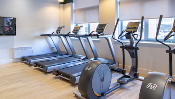 A gym with treadmills and elliptical machines.
