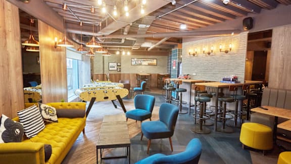 A modern cafe with yellow and blue chairs.