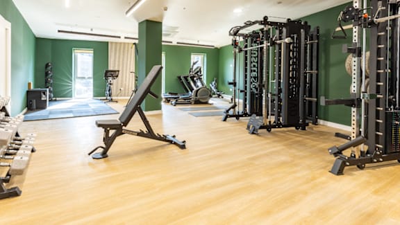 A gym with a variety of equipment including weights and weight machines.