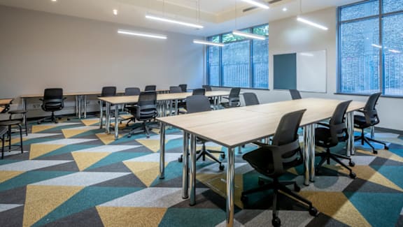 A conference room with a long table and chairs.