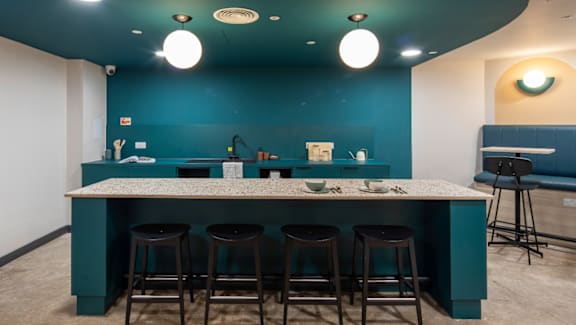 A kitchen with a bar area and stools.