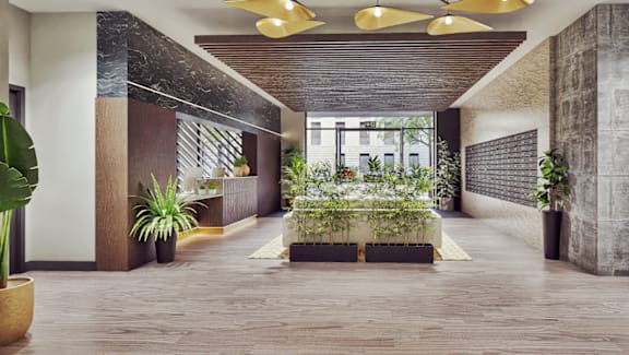 A long hallway with plants on either side and a yellow rug in the middle.
