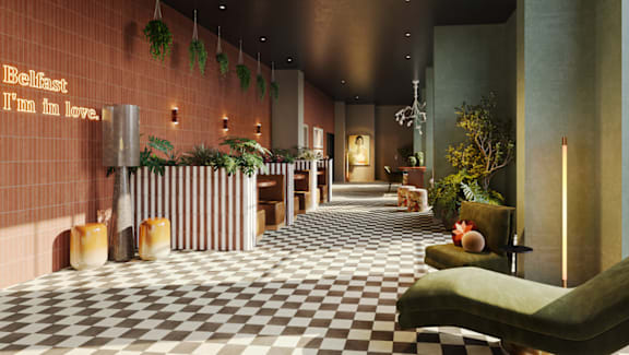 A long hallway with a checkered floor and green chairs on the right side.
