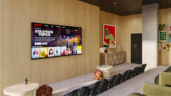A living room with a large screen displaying the show Stranger Things.