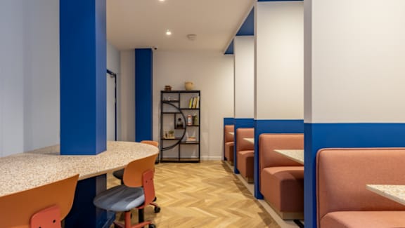 A row of orange chairs are lined up in a room.