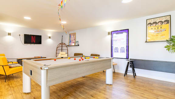 A room with a pool table and a chair.
