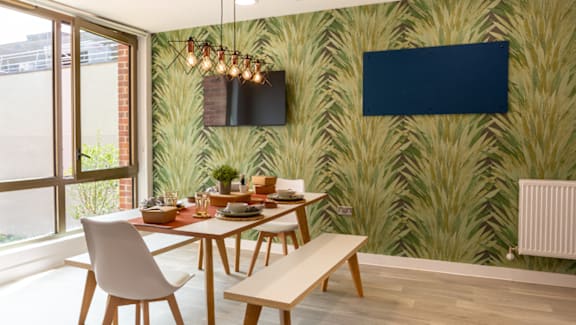 A dining room with a wooden table and chairs.